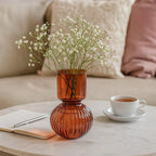 Vase rond en verre ambre sur une table lumineuse, parfait pour compositions florales modernes et chaleureuses